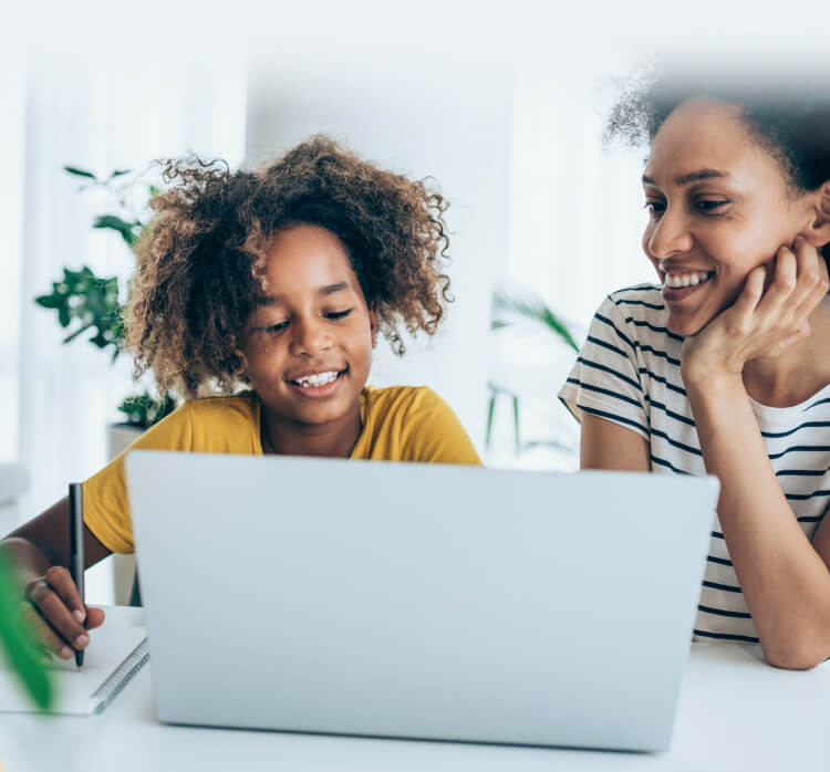 Madre e hija utilizan una computadora portátil que está iniciando Norton Family.